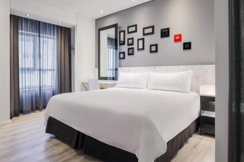 a bedroom with a large white bed and a desk at Protea Hotel Fire & Ice! by Marriott Pretoria Menlyn in Pretoria
