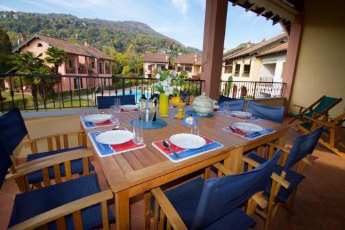 a wooden table and chairs on a patio with a view at Sunflower - Lake Maggiore Duplex w/ Terrace and Shared Pool in Lesa