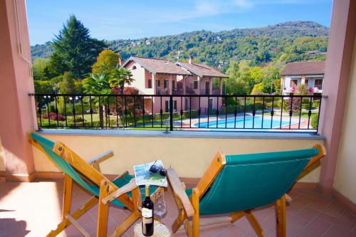 two chairs on a balcony with a view of a pool at Sunflower - Lake Maggiore Duplex w/ Terrace and Shared Pool in Lesa