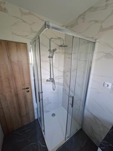 a shower with a glass door in a bathroom at Apartman Martina in Gospić