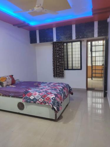 a bedroom with a bed with a blue ceiling at Shiv- Vatsalya Homestay in Nashik