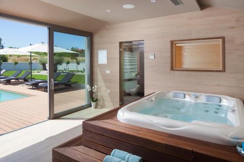 a bath tub in a room with a patio at Villa Royal Green - Happy Rentals in Labin