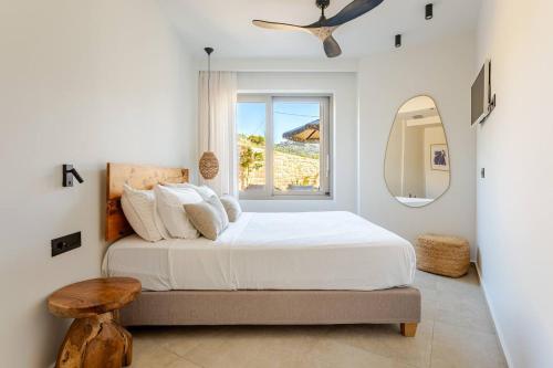 a white bedroom with a bed and a window at RIRIKA Beach Living, New Seaside Apartments in Plakias in Plakias