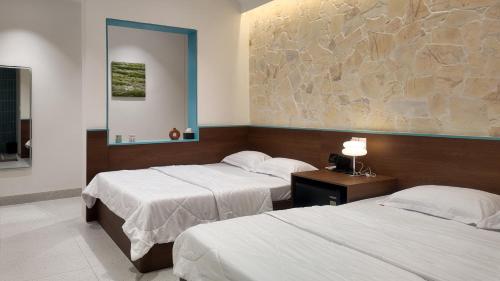 a bedroom with two beds and a painting on the wall at Mik Stay 2 in Danang