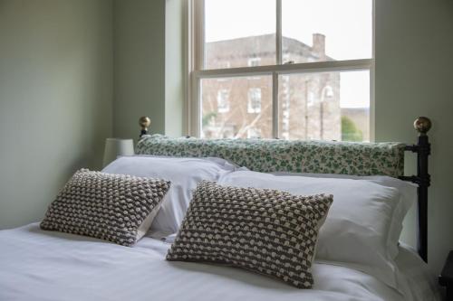 a bedroom with two beds with pillows and a window at Sheriff's Tower Cottage - West in Bishop Auckland