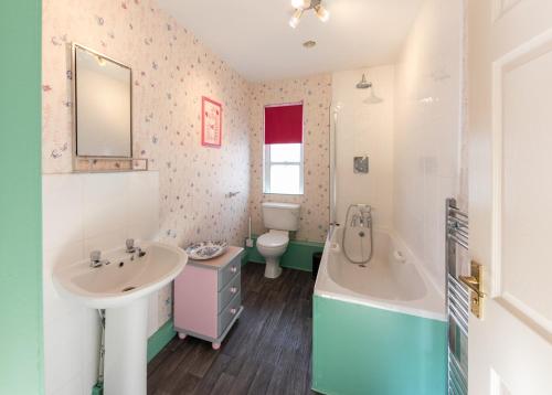 a bathroom with a sink and a tub and a toilet at Sheriff's Tower Cottage - West in Bishop Auckland