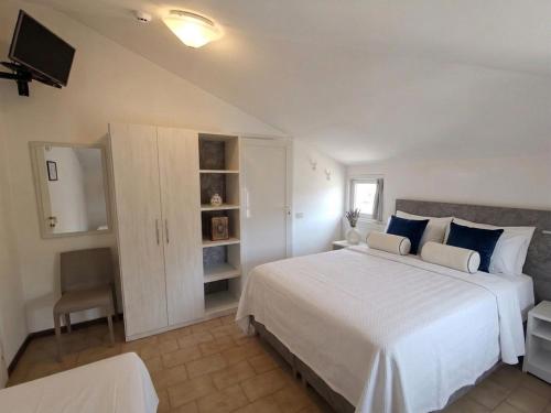 a bedroom with a large white bed with blue pillows at Hotel Villa Lieta in Rimini
