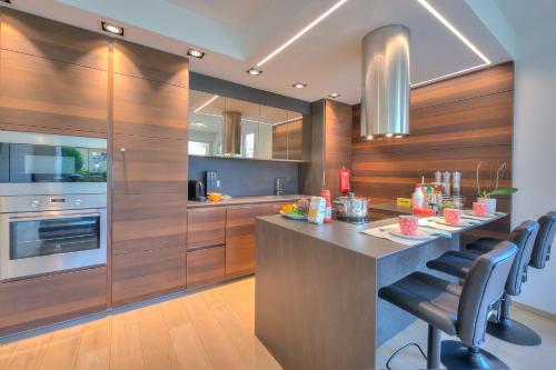 a kitchen with wooden walls and a island with chairs at Rebecca Garden with Terrace in Paradiso - Happy Rentals in Lugano