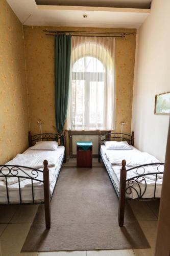 two beds in a room with a window at Mini-hotel Franko Park in Lviv