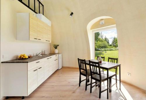 a kitchen with a table and chairs and a window at Kupolo patyrimas in Jurgeliškė