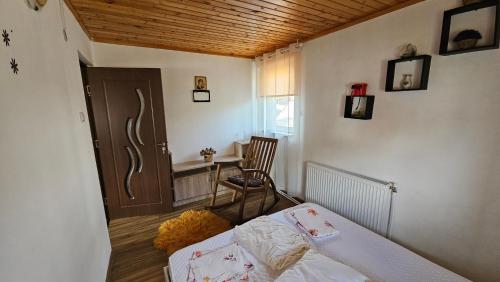 a bedroom with a bed and a table and a chair at Cheia House in Cheia
