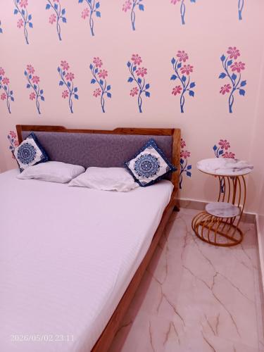 a bedroom with a bed with blue and pink flowers on the wall at Kedarnath villa in Kakarmatha