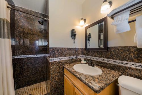 a bathroom with a sink and a shower at Clarion Collection Carmel Oaks Inn in Carmel