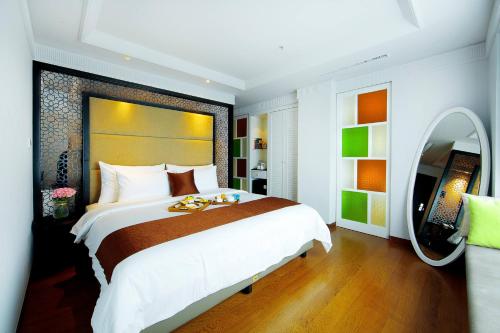 a bedroom with a large bed and a large mirror at De Paviljoen Bandung in Bandung