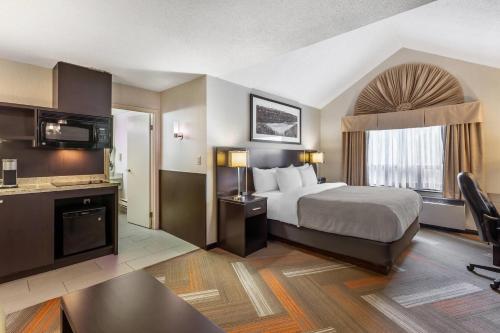 a hotel room with a bed and a television at Quality Hotel in Burlington