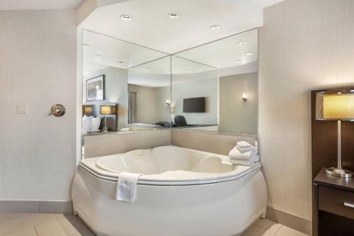 a large white tub in a bathroom with a mirror at Quality Hotel in Burlington
