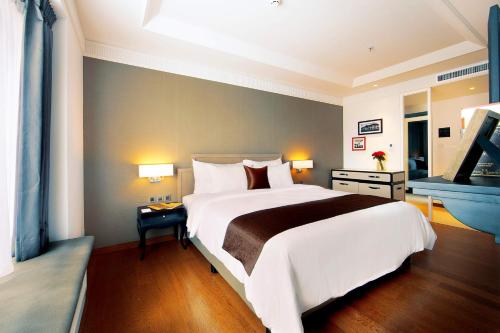 a bedroom with a large white bed and a blue wall at De Paviljoen Bandung in Bandung