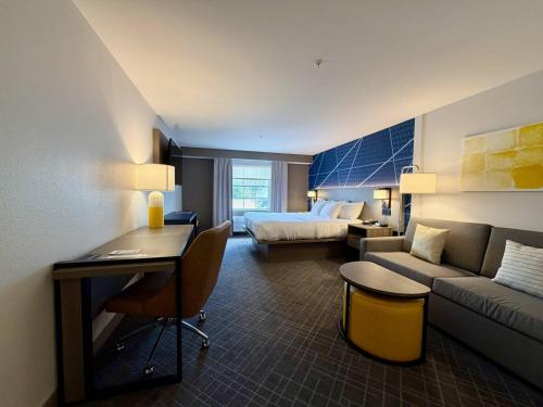 a hotel room with a bed and a couch at Comfort Inn & Suites Sturbridge-Brimfield in Sturbridge