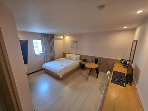 a hotel room with a bed and a table at Mc9Hotel in Uijeongbu