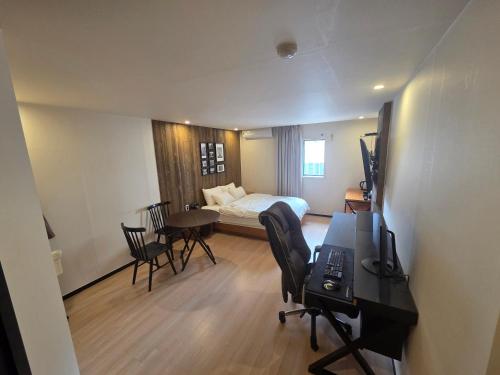 a hotel room with a bed and a desk with a desk at Mc9Hotel in Uijeongbu