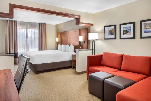 a hotel room with a bed and a couch at Comfort Suites Grand Rapids North in Comstock Park