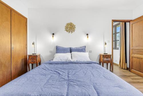 a bedroom with a large blue bed with two tables at Le Domaines Des Thermes - T2 in Gap