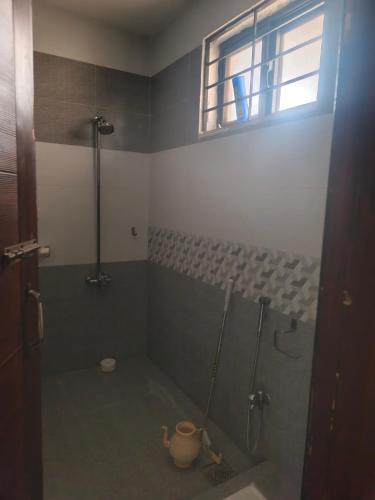 a bathroom with a shower and a toilet and a window at The 430 District in Islamabad