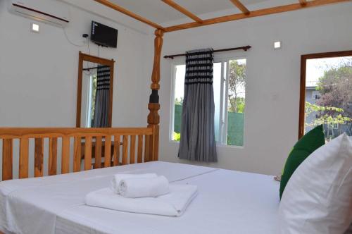 a bedroom with a bed with two towels on it at Airport Green Hotel in Katunayake