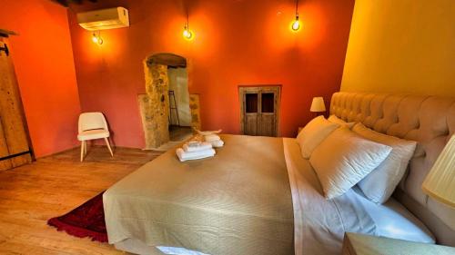 a bedroom with a large bed with an orange wall at Avalon Boutique Hotel Rhodes in Rhodes Town