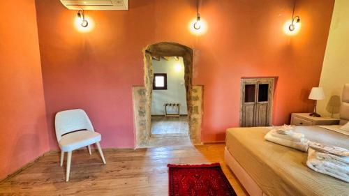 a bedroom with an orange wall with a chair and a mirror at Avalon Boutique Hotel Rhodes in Rhodes Town