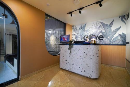 a room with a counter with a wall with plants at Olive Hotel Nagawara by Embassy Group in Bangalore