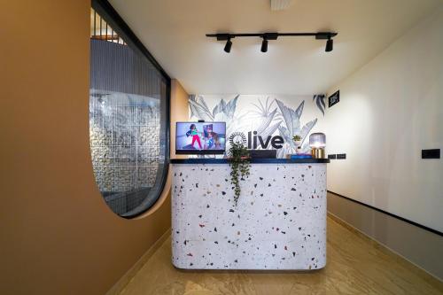 a room with a counter with a tv on it at Olive Hotel Nagawara by Embassy Group in Bangalore