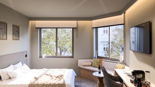 a bedroom with a bed and a desk and two windows at Nixon Downtown, a member of Nixon Hotels in Athens