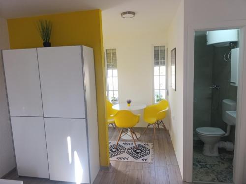 a kitchen with a table and yellow chairs in a room at VA vikendica Tesanj in Tešanj