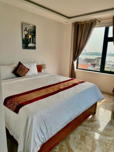 a bedroom with a large bed with a large window at Flamengo hotel in Dong Hoi