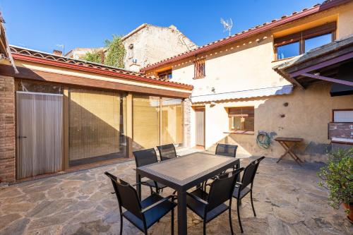 a patio with a wooden table and chairs at Hauzify I Casa Rourell in El Morell