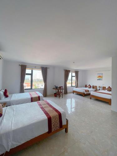 a large room with three beds and a couch at Flamengo hotel in Dong Hoi