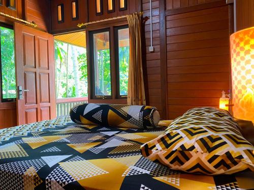 a bedroom with a bed with pillows on it at Ghia Boutique Homestay in Batuangus