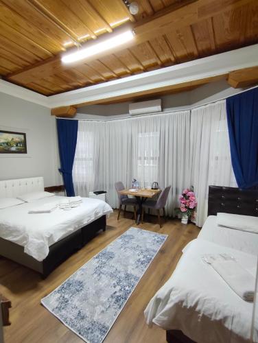 ein Schlafzimmer mit zwei Betten und einem Tisch mit einem Esszimmer in der Unterkunft Kule Pansiyon in Bursa