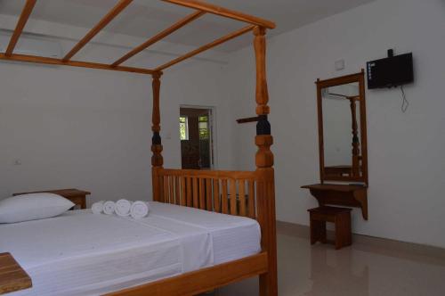 a bedroom with a bed with white sheets and a mirror at Airport Green Hotel in Katunayake