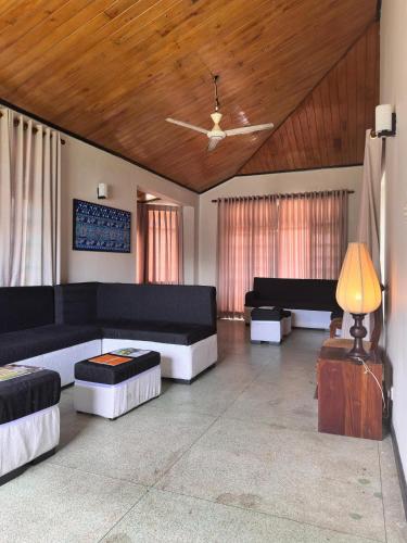a living room with black and white furniture and a ceiling at Villa i in Dehiwala