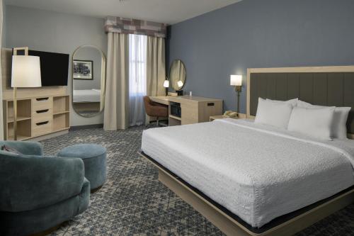 a bedroom with a bed and a desk and a mirror at Hampton Inn & Suites Montgomery-Downtown in Montgomery