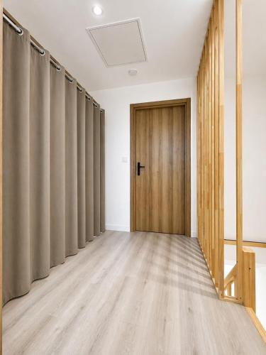 an empty room with curtains and a door at Chez Mimi in Maubert-Fontaine