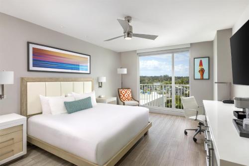 a bedroom with a bed and a desk and a window at Sunseeker Resort Florida Gulf Coast, Curio Collection Hilton in Punta Gorda