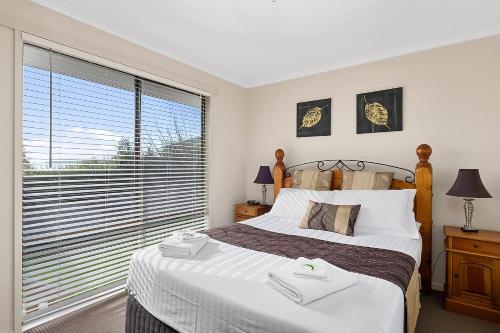 a bedroom with a bed and a large window at Mirramar House in Kingston Beach