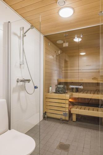 a bathroom with a shower and a glass shower stall at City & Forest Relax Room with Private Sauna & Garden in Espoo