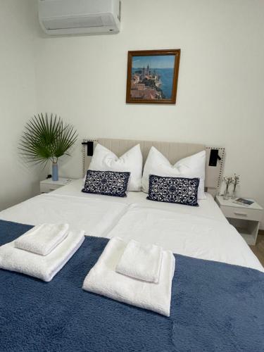 a bedroom with a white bed with towels on it at Villa Csery 1stzime in Supetarska Draga