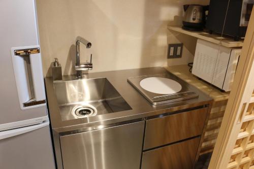 a small kitchen with a sink and a toilet at Yanaka Kotobuki Sou in Tokyo