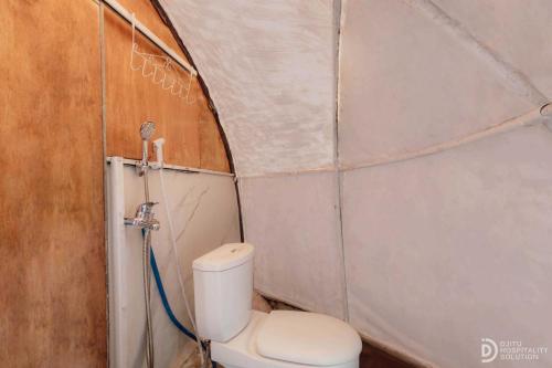 a small bathroom with a toilet in a tent at Fortune Glamping in Diyeng