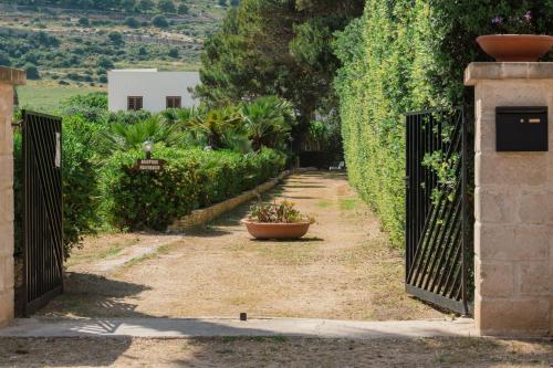 an entrance to a garden with a fence and a flower pot at Blu Vacanze Apartments in Favignana
